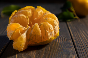 Peeled tangerine on a dark background with space for text. Wallpaper, poster.