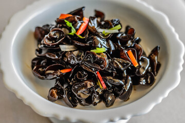 an appetiser of Fungus with Preserved Vinegar served in a white china plate