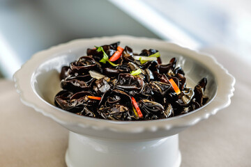 an appetiser of Fungus with Preserved Vinegar served in a white china plate