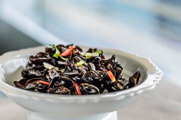 an appetiser of Fungus with Preserved Vinegar served in a white china plate