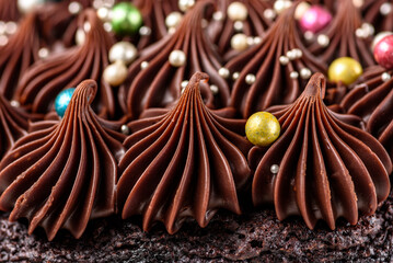 A rich indulgent chocolate cake top with chocolate swirls and brightly coloured candy