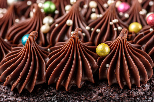 A rich indulgent chocolate cake top with chocolate swirls and brightly coloured candy