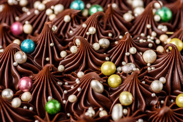 A rich indulgent chocolate cake top with chocolate swirls and brightly coloured candy