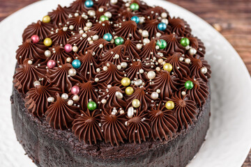 A rich indulgent chocolate cake top with chocolate swirls and brightly coloured candy