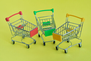 Three empty shopping cart on the yellow background