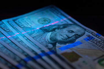 100 dollars banknot currency in UV light protection.Dollars in UV light.Dollars currency in UV light protection.