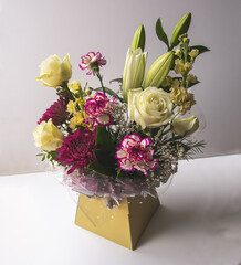 A spring flower arrangement with chrysanthemums, lilies and naomi roses.