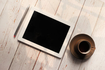 Flat composition of digital tablet and tea on wooden background 