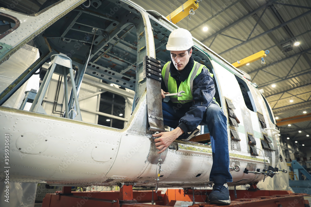 Wall mural portrait of a caucasian man , factory engineer in work clothes controlling the work process at the h