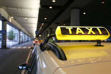 Taxi sign on yellow cab on rainy day