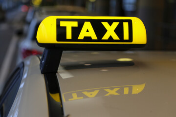 Taxi sign on yellow cab on rainy day