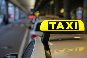 Taxi sign on yellow cab on rainy day