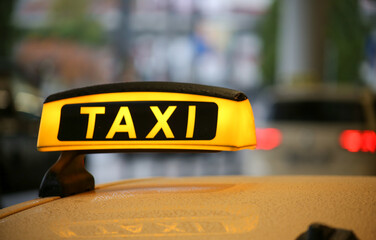 Taxi sign on yellow cab on rainy day