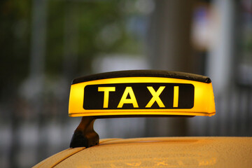 Taxi sign on yellow cab on rainy day