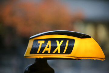 Taxi sign on yellow cab on rainy day