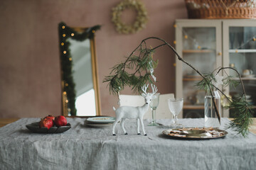 Festive Christmas home. Table setting with rustic decorations for Christmas. New Year decorations in modern interior design. 