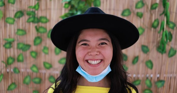 Trendy asian girl wearing protective face mask under chin during coronavirus outbreak - Portrait of young japanese woman during Covid-19 outbreak - Health care and millennial generation concept