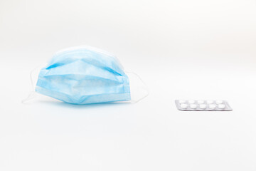 protective mask and blister of tablets on white