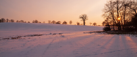 schneebedeckte Winterlandschaft bei Sonnenuntergang
