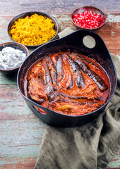 Modern style slow cooked Persian lamb eggplant stew khoresh bademjan served with rice and yoghurt as close-up in a Design pot