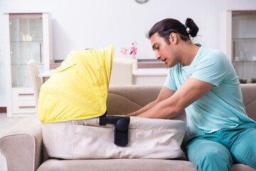Young male parent looking after newborn at home