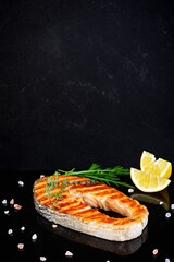 Grilled salmon fish on stone board. Salt atlantic salmon fried on grill with lemon