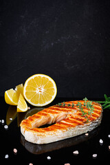 Grilled salmon fish on stone board. Salt atlantic salmon fried on grill with lemon