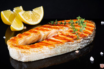 Grilled salmon fish on stone board. Salt atlantic salmon fried on grill with lemon