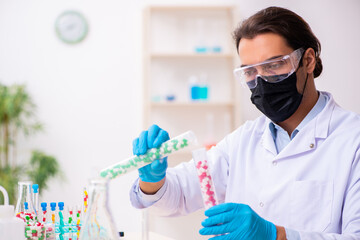 Naklejka premium Young male chemist in drug synthesis concept