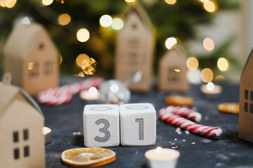 December 31. Wooden cubes calendar, christmas decorations, paper houses and Christmas tree. Christmas Wishes Concept, New Year eve