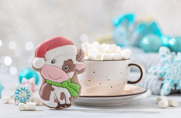 Christmas gingerbread in glaze in the form of a bull. Christmas symbols, on table with New Year's decor.