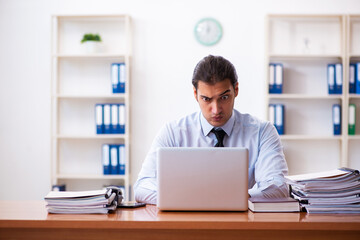 Naklejka premium Young male employee working at workplace