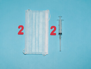 The number 2021 is made up of red plastic magnets ,a medical mask, and a syringe.Concept:...