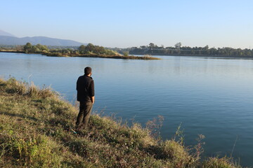 Fototapeta na wymiar A HUMAN LOOKING TOWARDS A LAKE AT A PLACE DAAKPATTHER. 