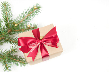 Christmas decoration, large gift box with red bow and Christmas tree branch with yellow balls isolated on white background