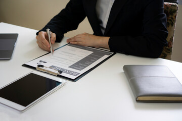 The female financial staff is checking the applicant's job application documents and considering the qualifications of the applicant going through work, job application concepts.