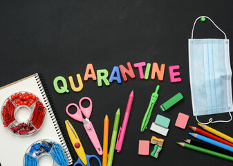 inscription quarantine from multicolored plastic letters and school supplies on black chalk board