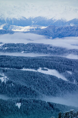 Viste da alta quota della Val di fiemme, con montagne e nuvole basse.