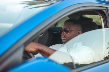 Black stylish man driving his new car