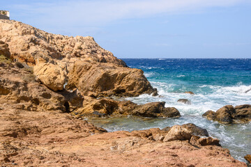 Fototapeta na wymiar Rocky coast of Koumbara beach located on Ios Island. Cyclades, Greece