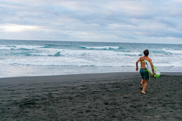 Person running on the beach going excited to surf