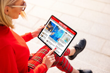 Woman reading news online on the tablet computer