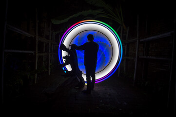 One person standing alone against beautiful Colourful circle light painting as the backdrop