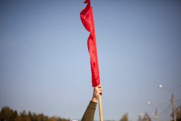 Red flag in hand. Workers' protest symbol red banner. 