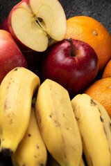 Naklejka na ściany i meble grapes tangerine bananas and apples on a dark pot