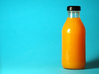 Juice bottle on a blue background.  Orange juice bottle. Carrot juice bottle.