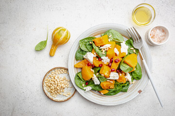 Salad with roasted pumpkin, cheese, spinach, Pine nuts and seasonings on white background, top view