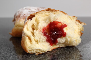 Doughnut without a hole filled with jam with sugar on top