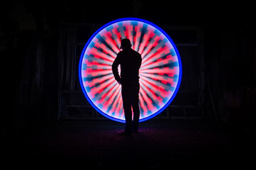 One person standing alone against beautiful Colourful circle light painting as the backdrop