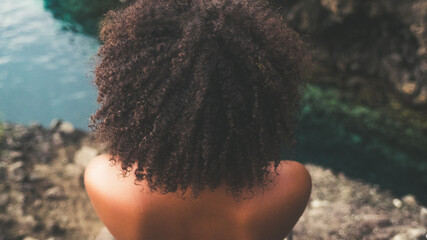 Black woman with afro hair on a Caribbean cliff